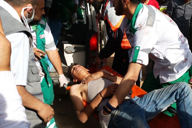An injured man is carried by medics on a stretcher